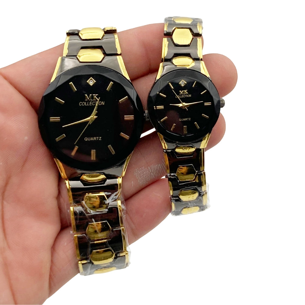 Two gold and black watches held in a hand against a white background