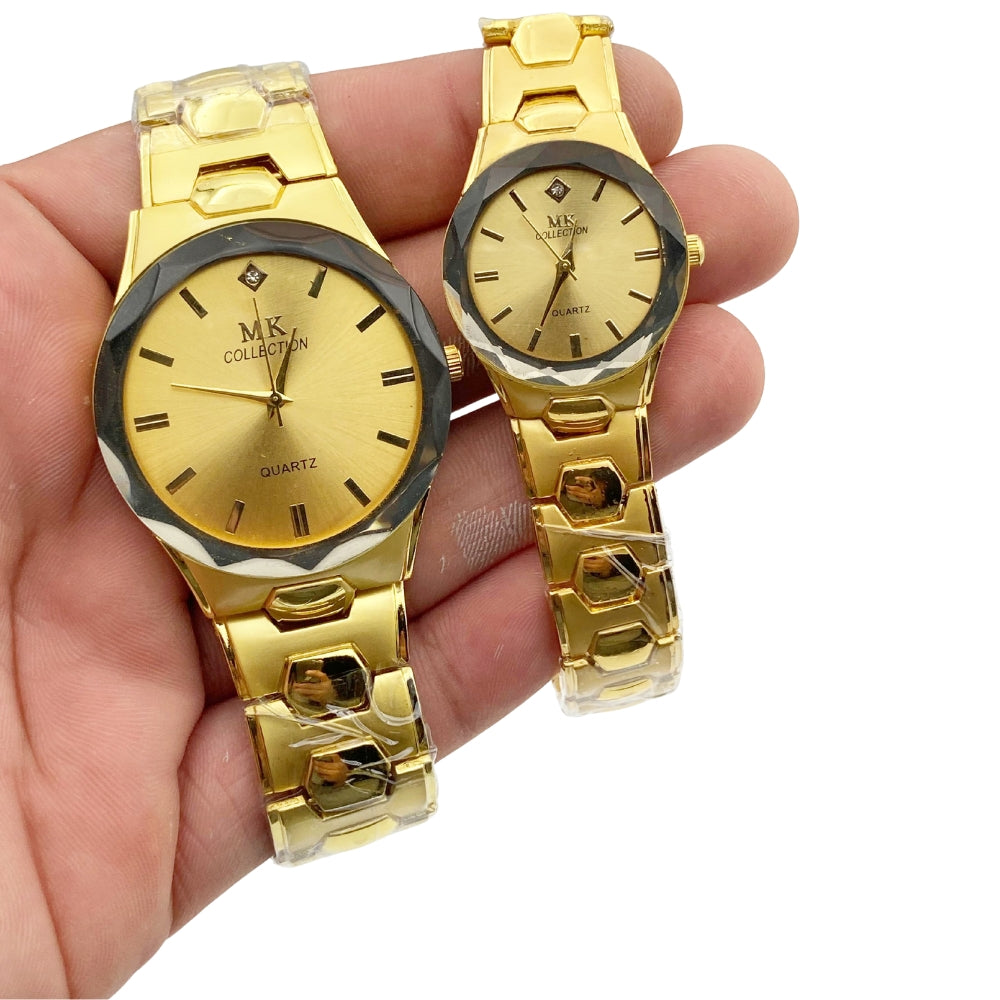 Two gold watches held in a hand against a white background