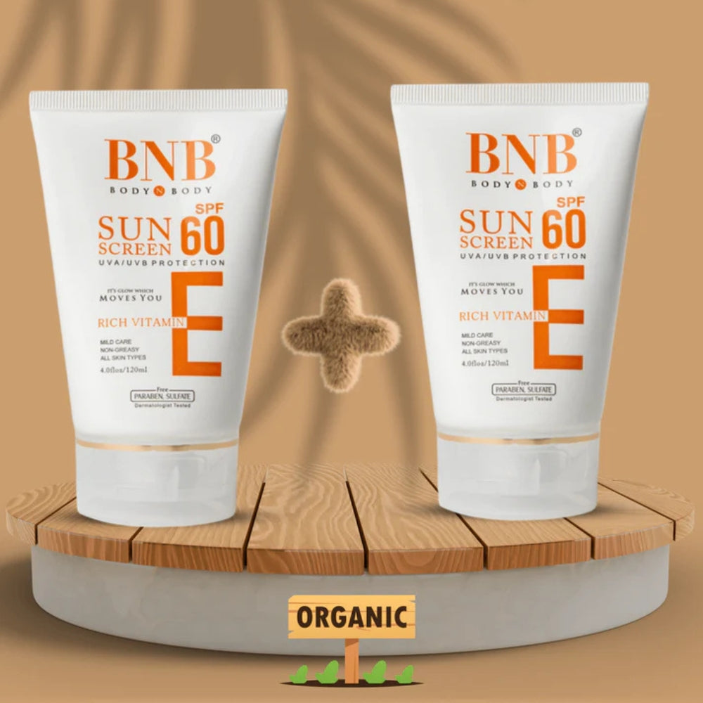 Two bottles of BNB sunscreen with SPF 60 on a wooden stand against a brown background.