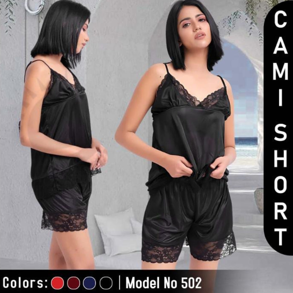 Woman wearing a black satin camisole with lace trim and matching shorts, standing against a neutral background.