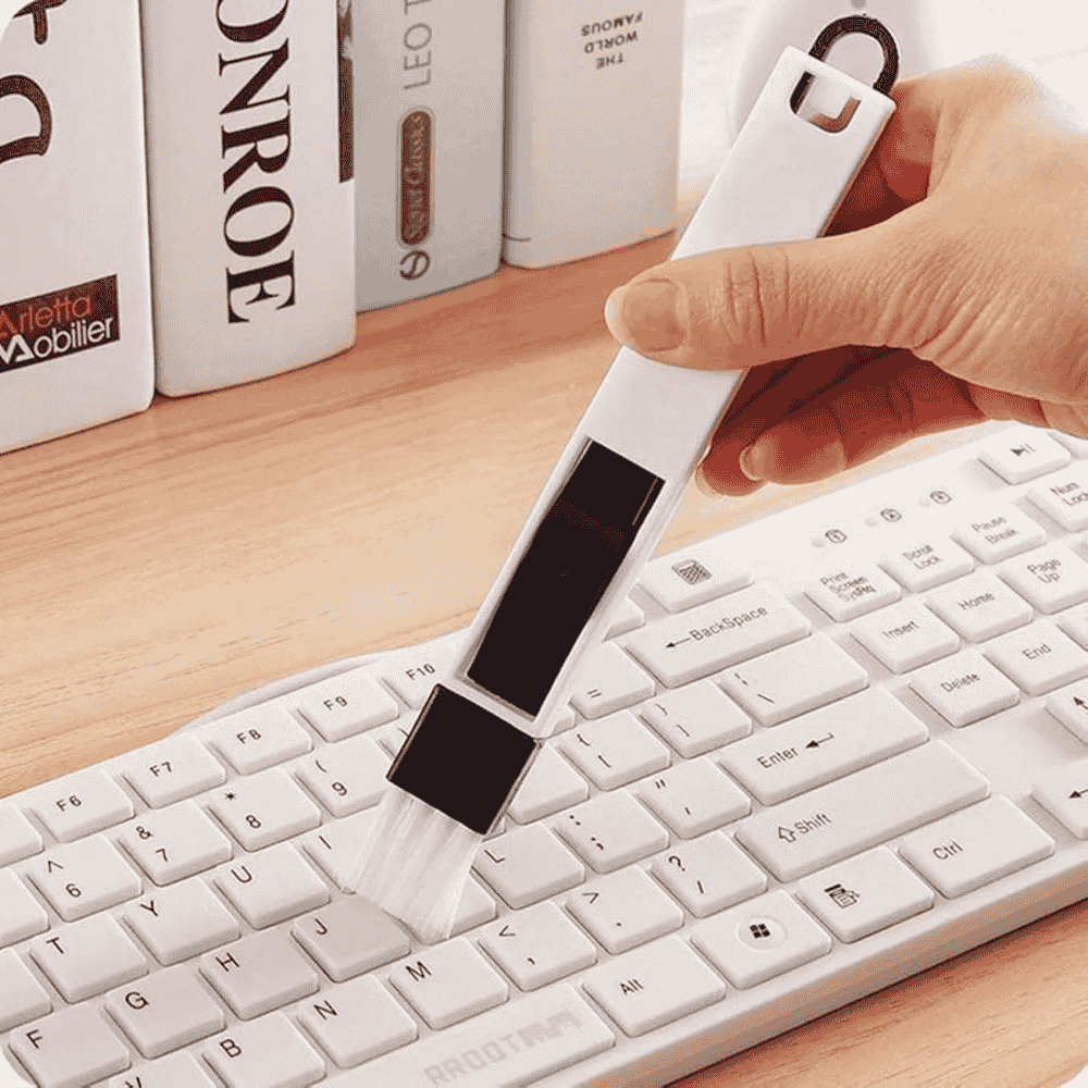 Using the cleaning brush on a computer keyboard