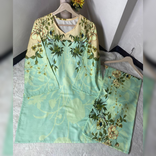 Floral dress with green and yellow pattern on a hanger against a white wall.