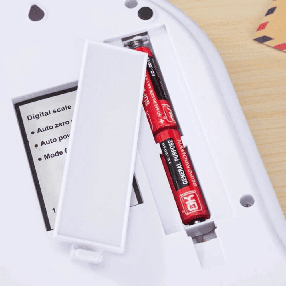 Red syringe with a label in a white container on a wooden surface