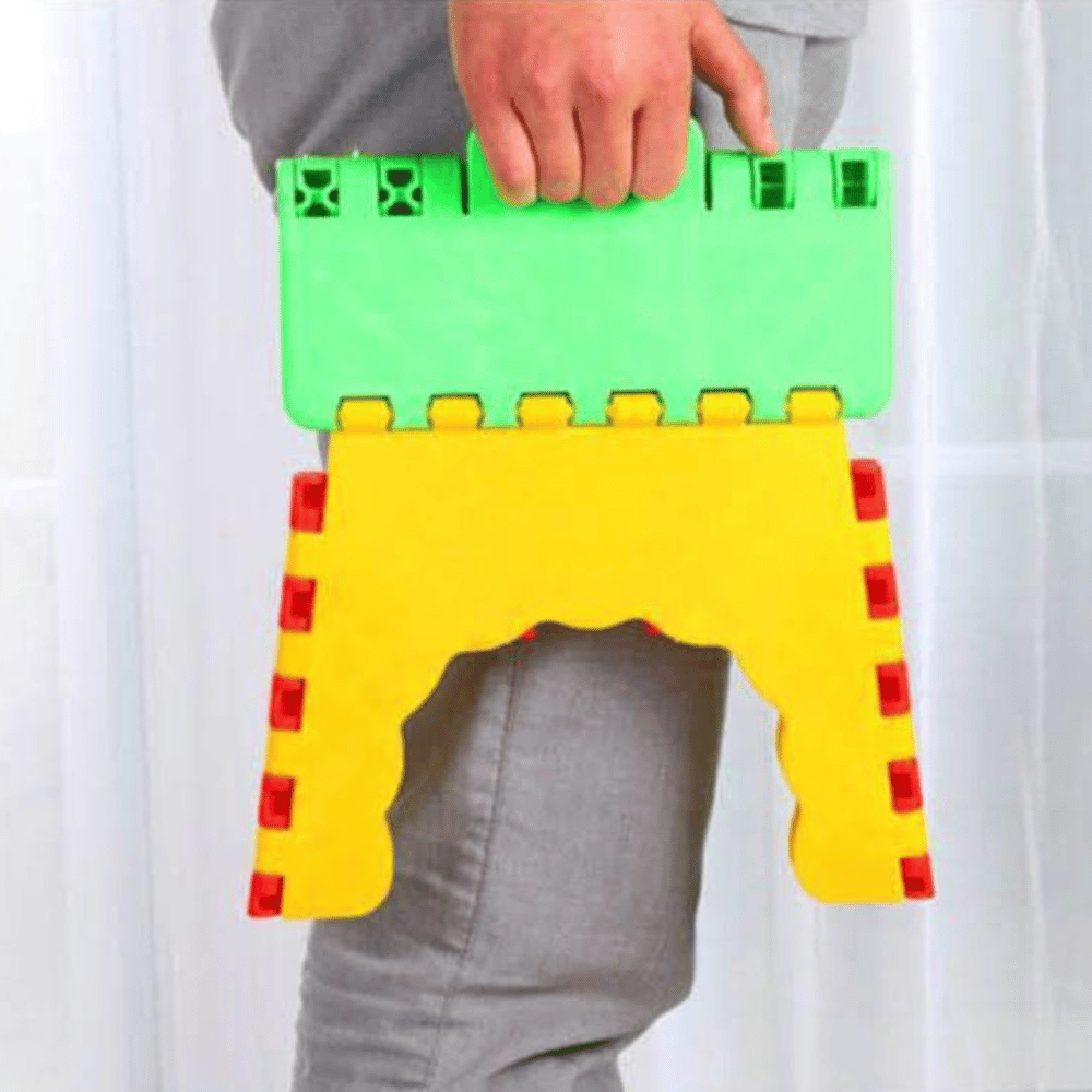 Colorful folding stool made of interlocking blocks held by a person against a white background