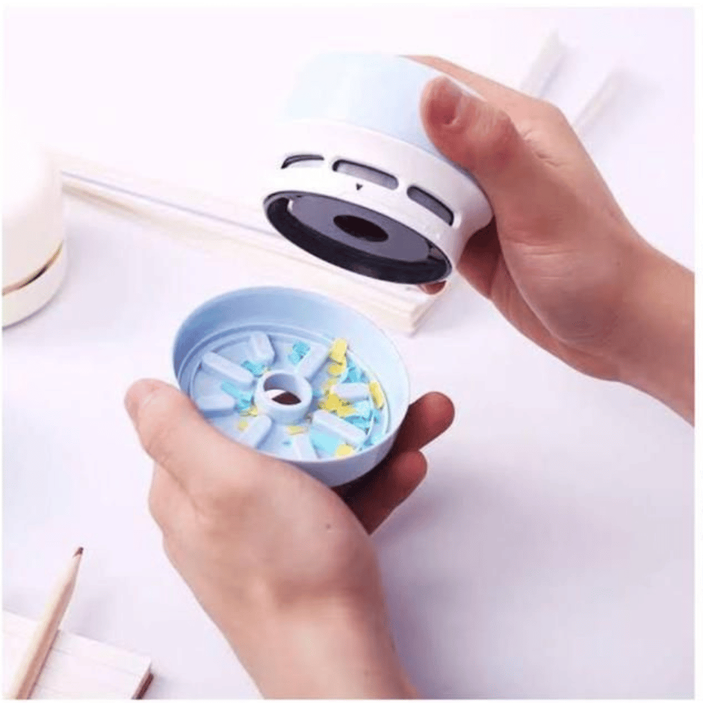 Hand holding a small blue and white device with a white background