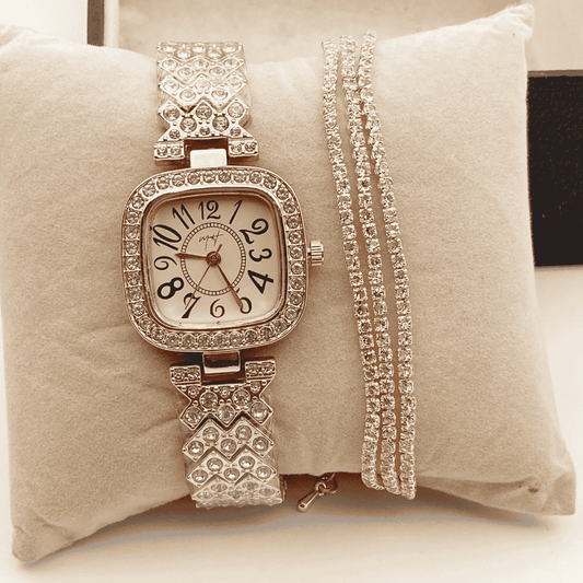 Silver watch with decorative band and matching bracelet on a beige cushion
