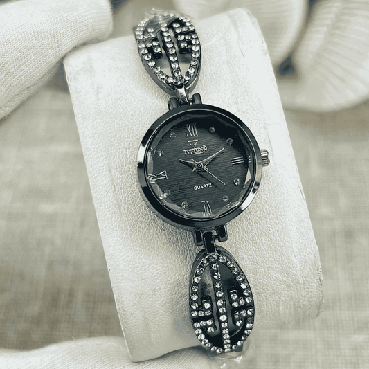 Black wristwatch with decorative band on a white cushion
