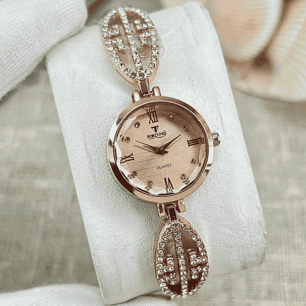 Rose gold watch with decorative strap on a white cushion