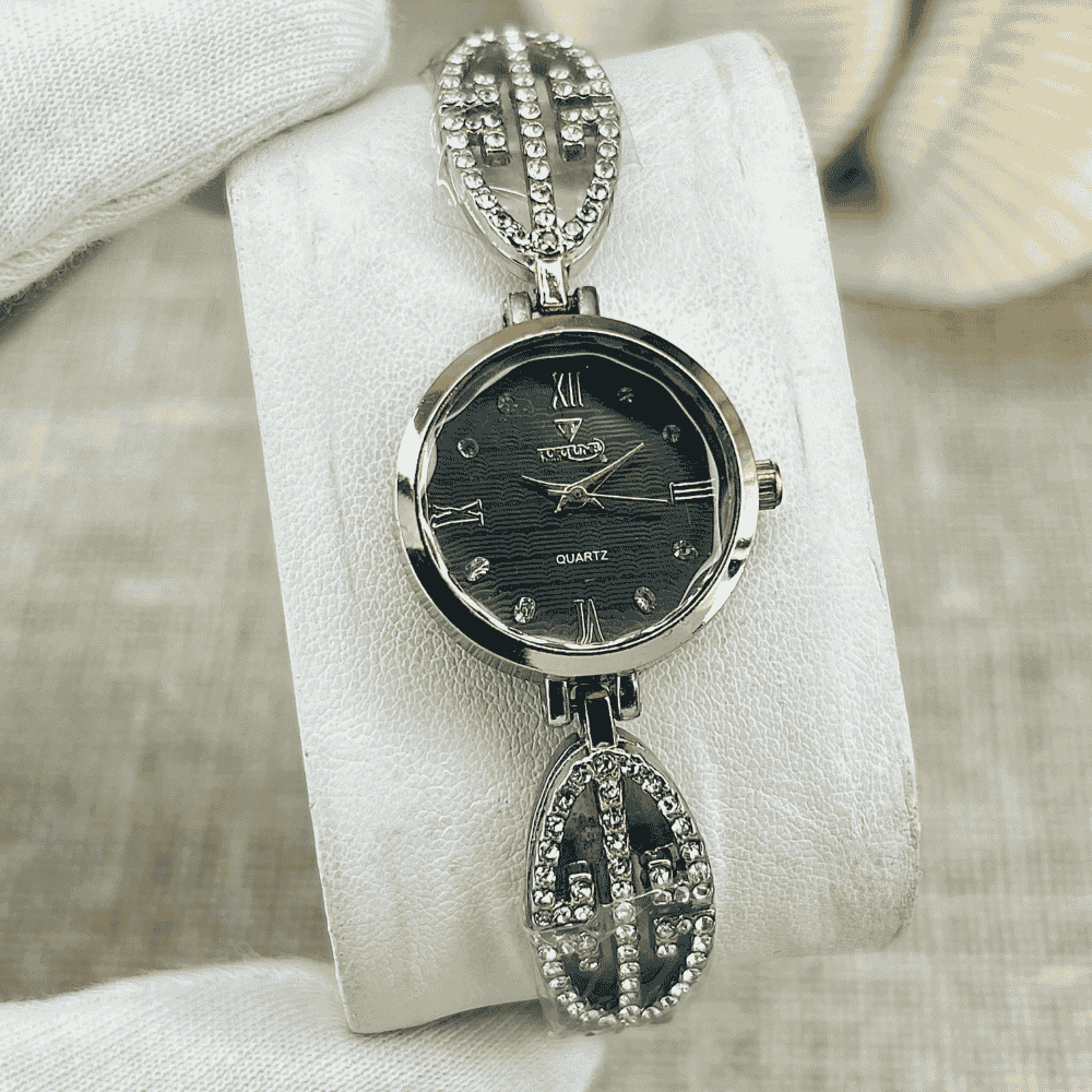Silver watch with decorative chain on a white cushion