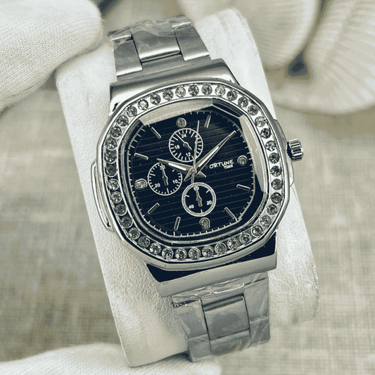 Silver watch with gemstone accents on a white cushion