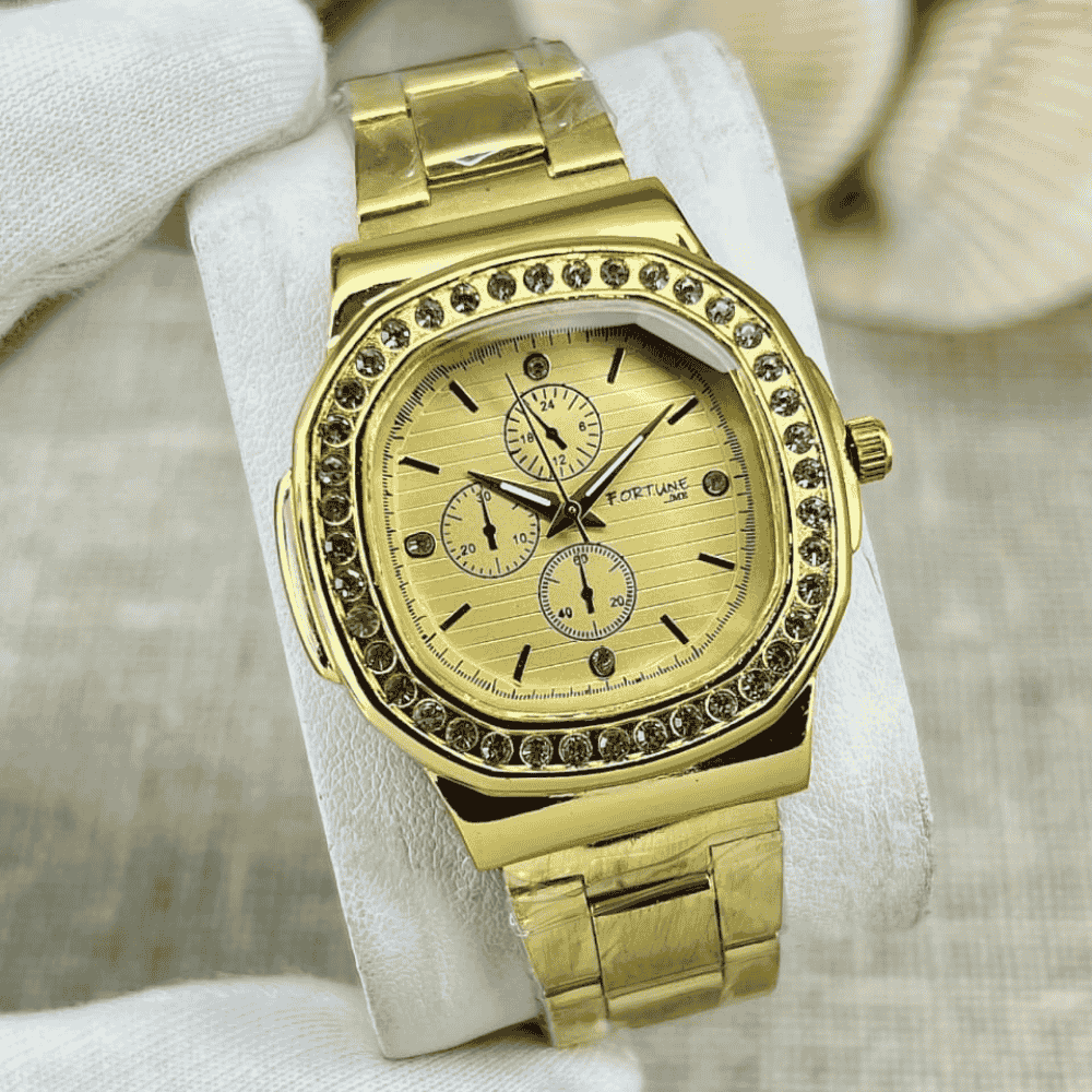 Gold wristwatch with gemstone accents on a white cushion
