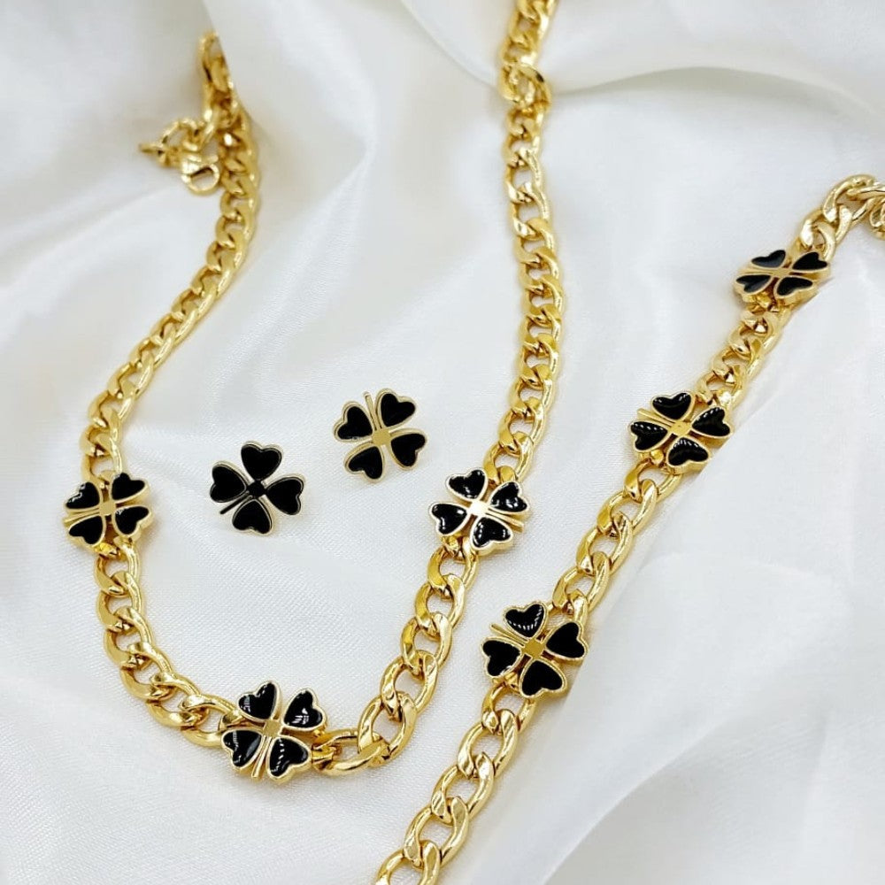 Gold necklace and earrings with black clover designs on a white background
