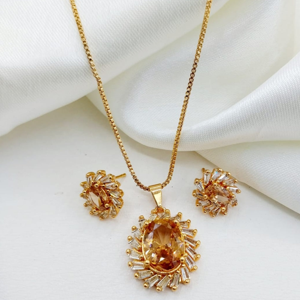 Gold jewelry set with pendant and earrings on a white fabric background