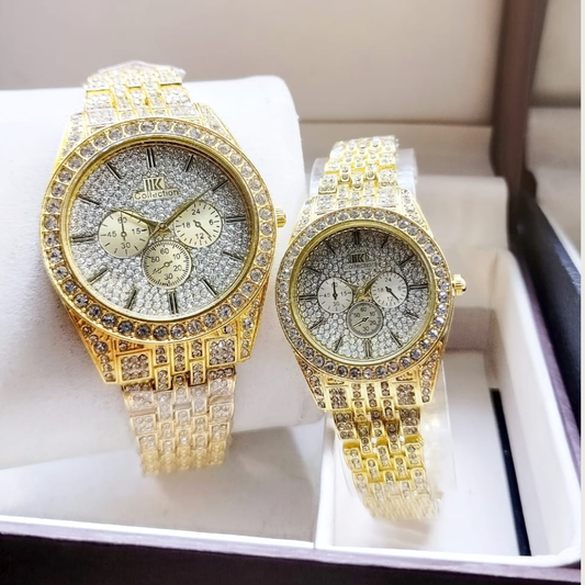 Two gold watches with diamond-studded faces on a white surface.