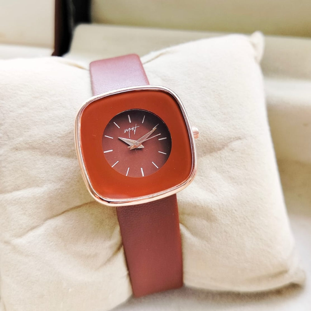 Watch with a pink strap and red face on a white cushion