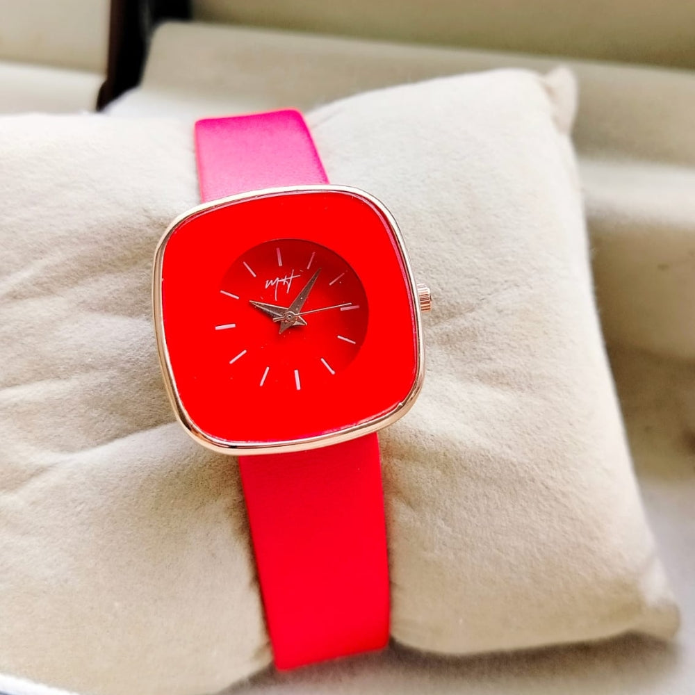Wristwatch with red face and pink strap on a beige cushion