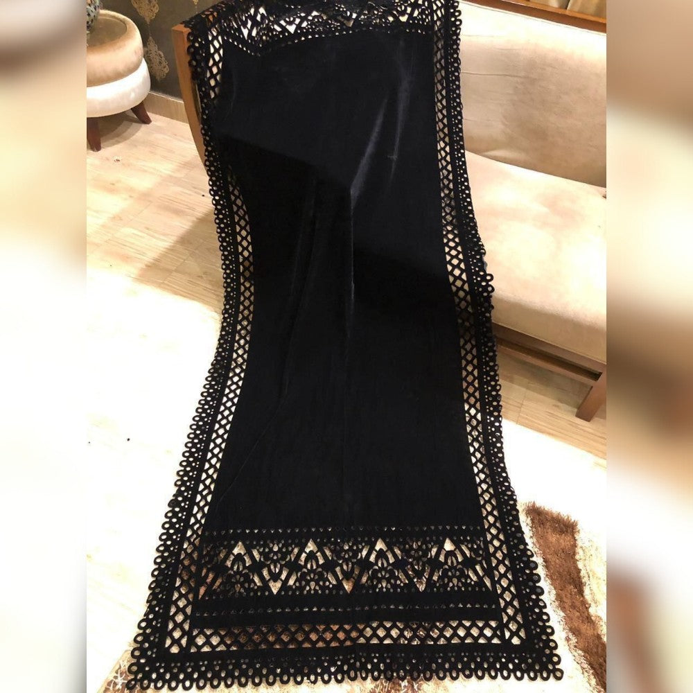 Black lace dress on a chair with a blurred indoor background