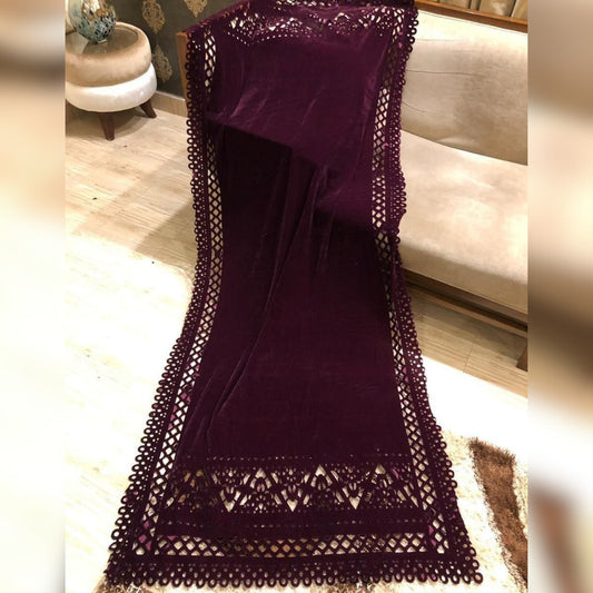 Purple fabric with lace detailing on a wooden floor.