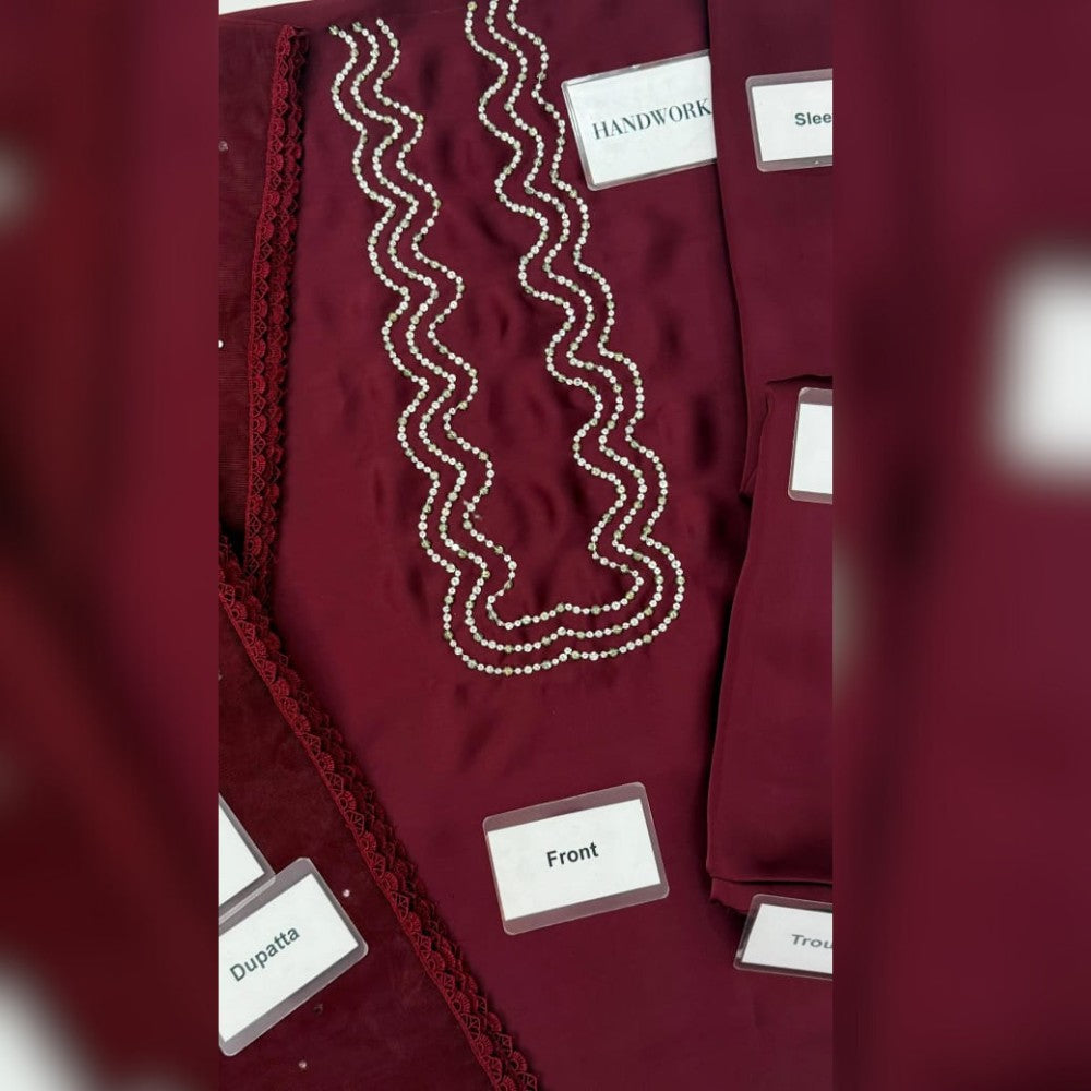 Maroon garment with white text labels on a blurred background