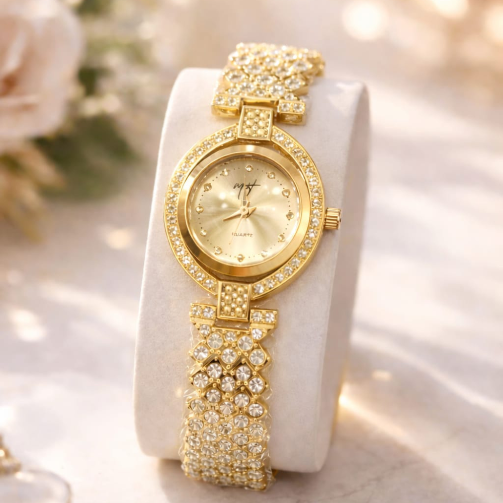 Gold wristwatch with decorative band on a white cushion, floral background