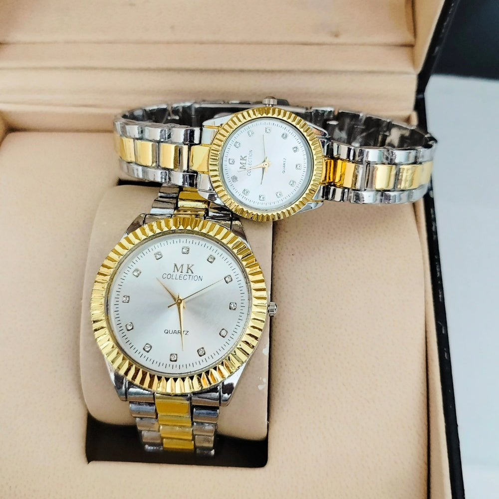 Two gold and silver watches with diamond-studded faces on a beige cushion.