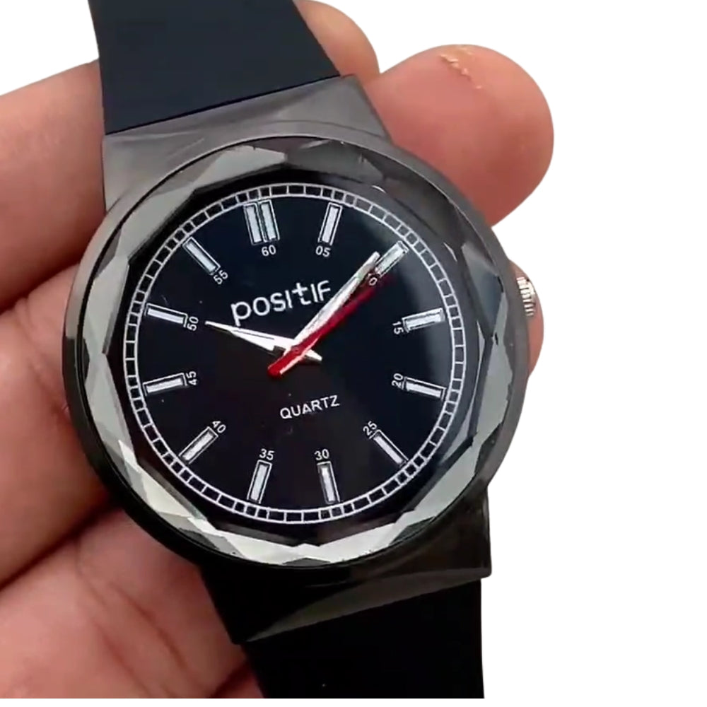 Black wristwatch with 'positif' branding held in a hand against a white background