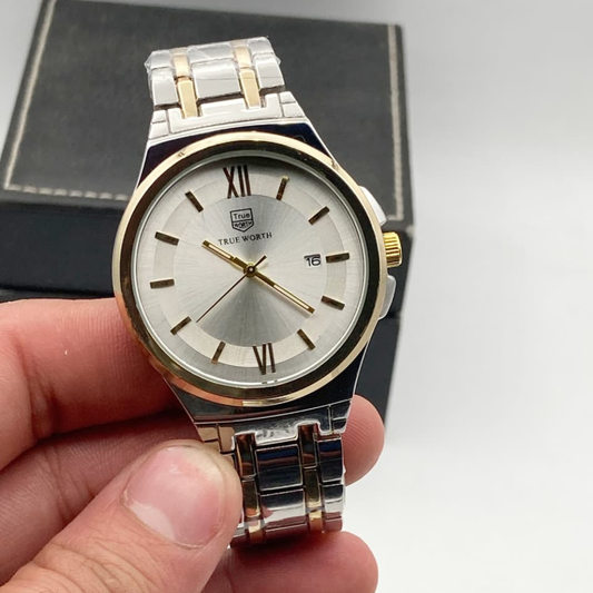 Silver and gold watch held in a hand with a neutral background