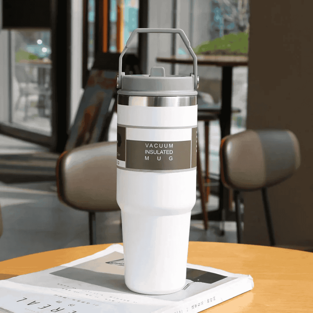 Vacuum insulated mug on a table with a blurred cafe background