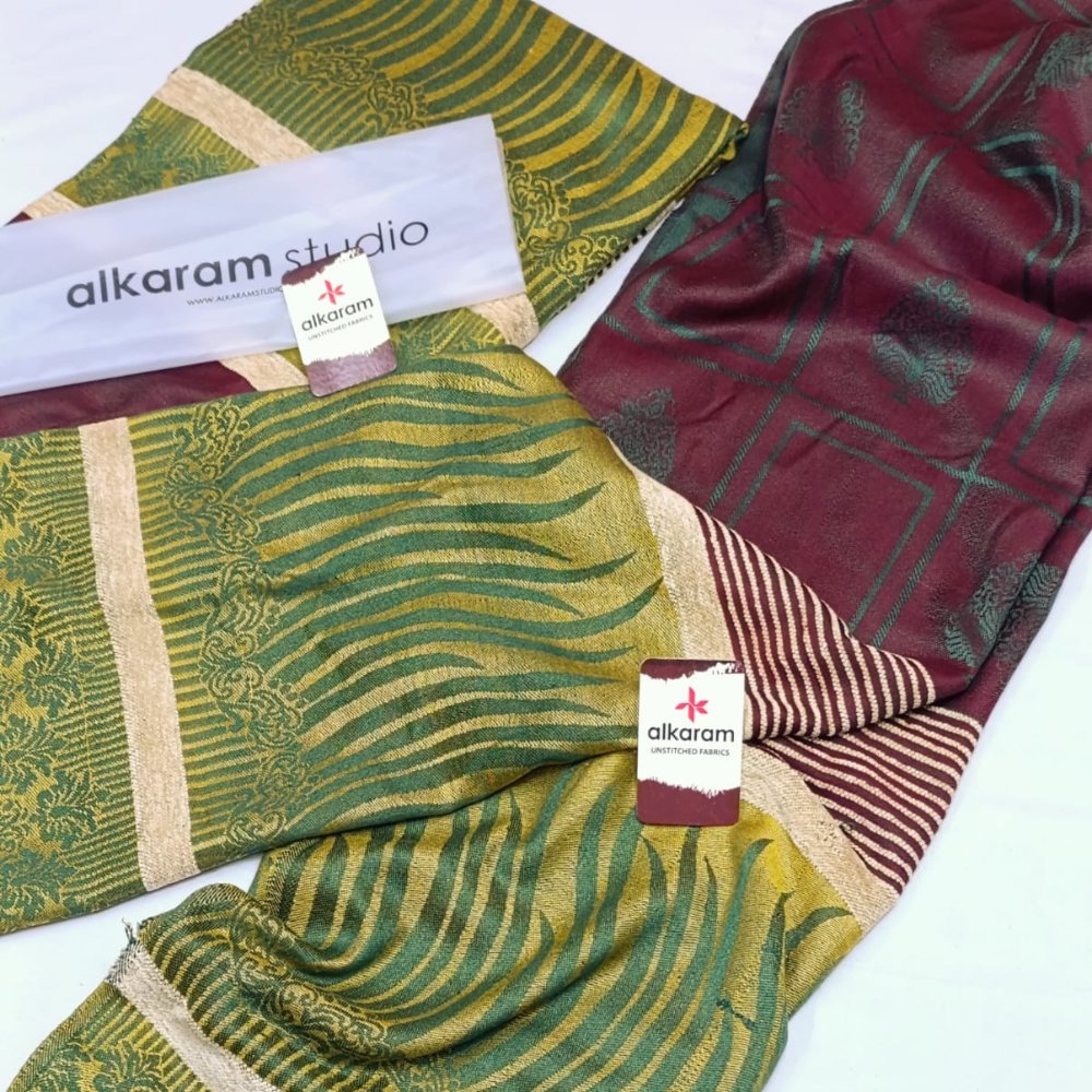 Two patterned scarves with 'alkaram studio' branding on a white background