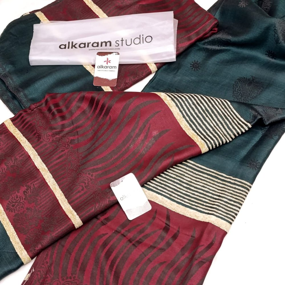 Two patterned scarves with visible 'alkaram studio' branding on a white background.