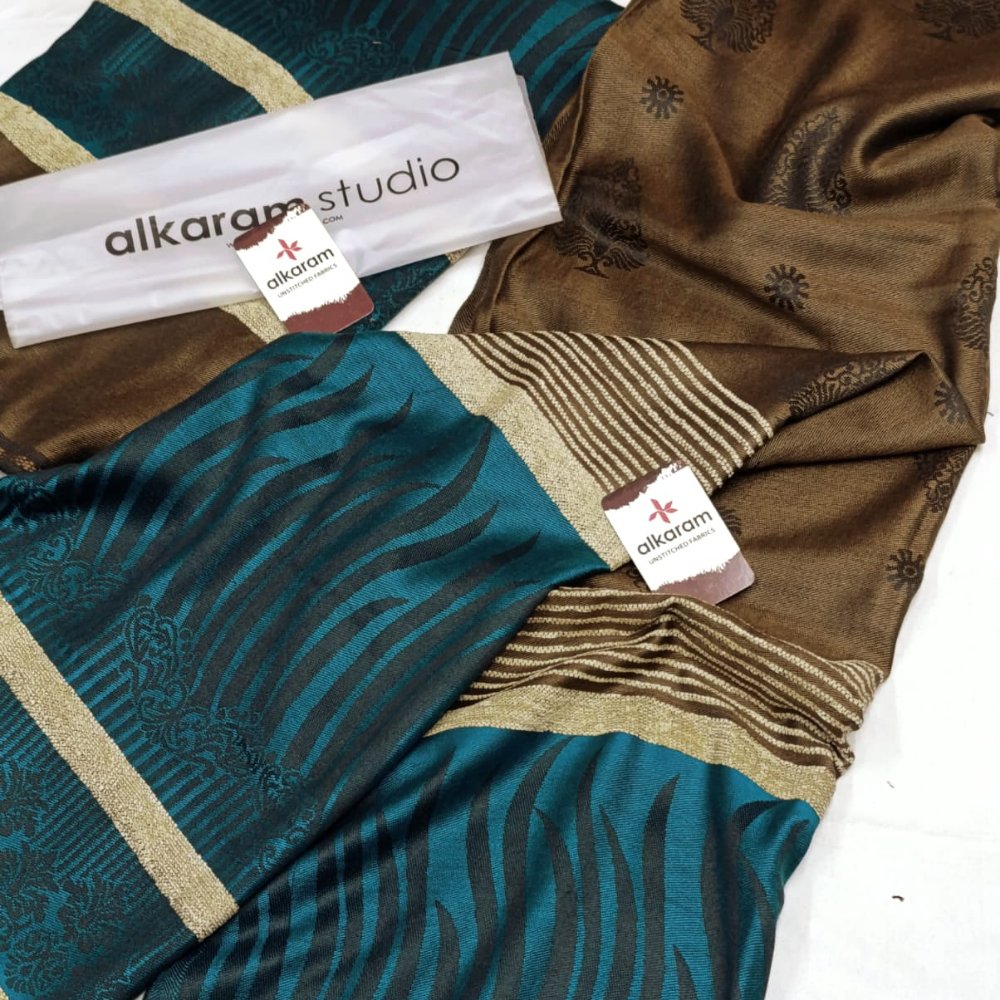 Two patterned scarves with visible 'alkaram studio' branding on a white background.