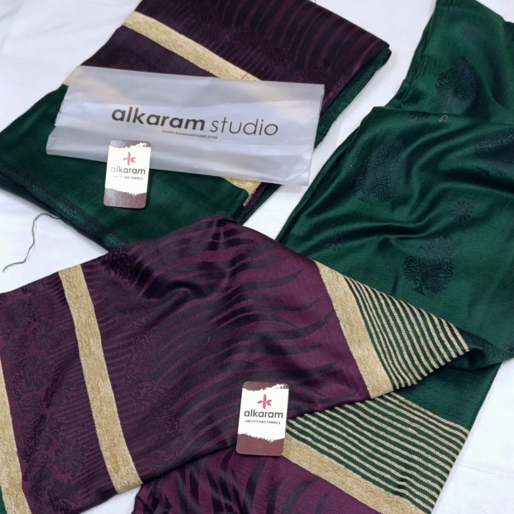 Two patterned scarves with 'alkaram studio' branding on a white background