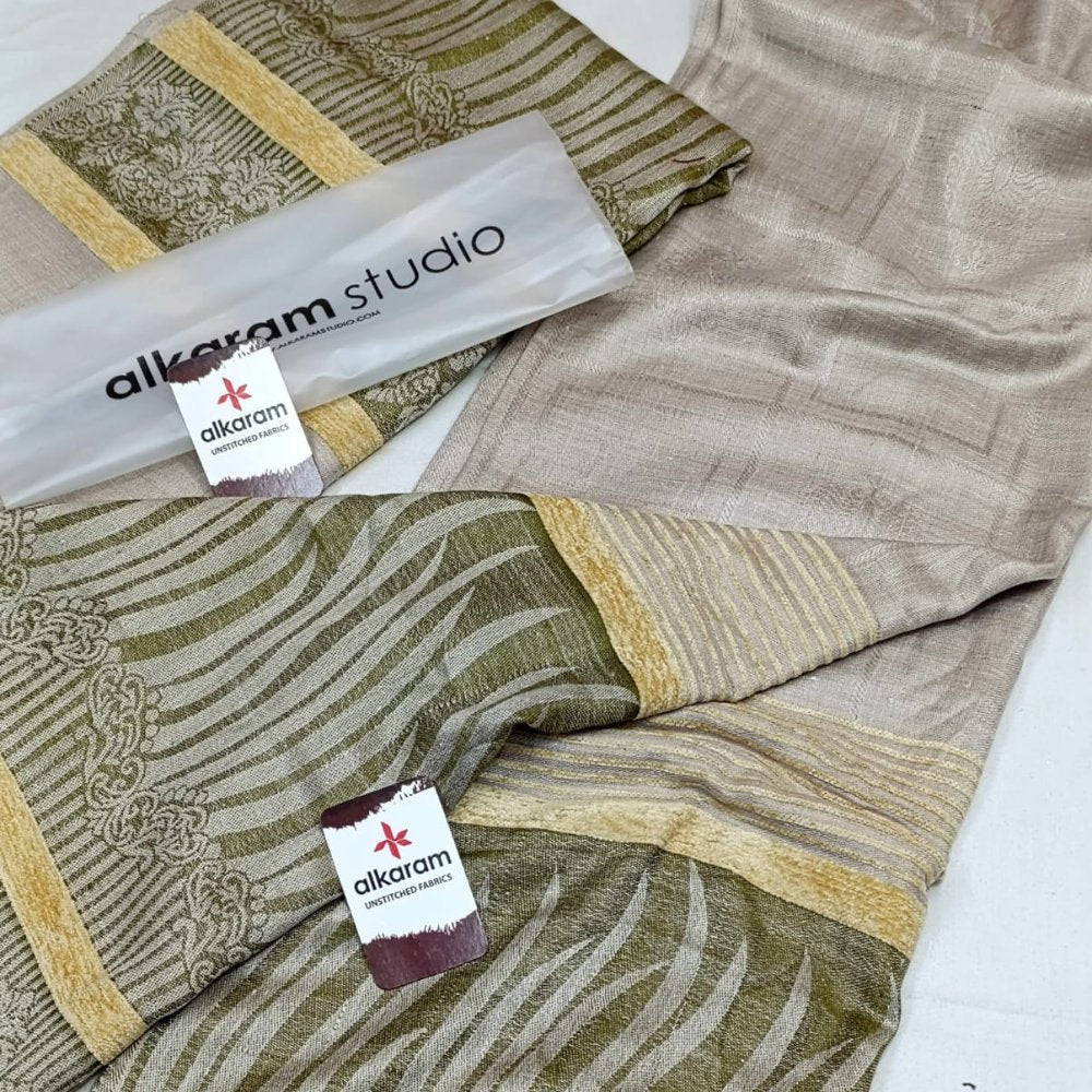 Folded fabric with 'alkaram studio' branding on a white background