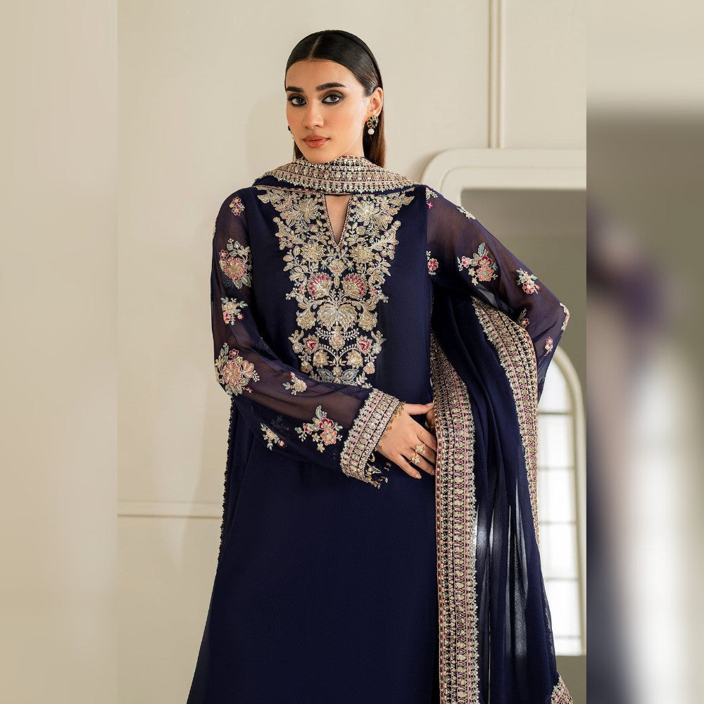 Woman wearing a navy blue embroidered outfit with a beige background