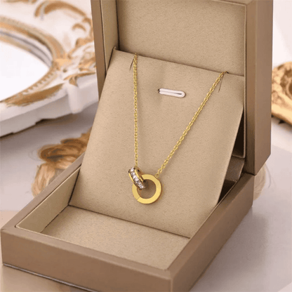 Side front view of gold plated branded locket set in its box