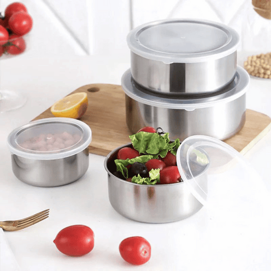 Set of stainless steel food containers with food on a white background