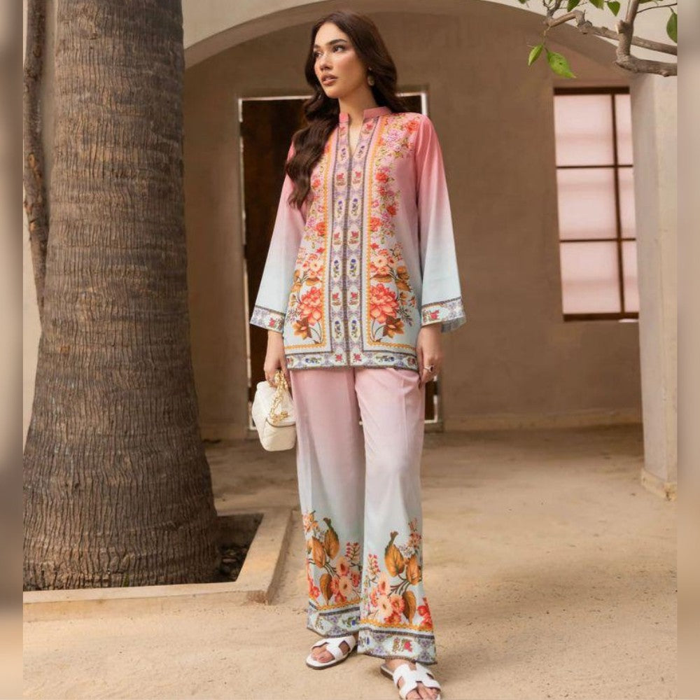 Woman in a floral outfit standing in a sunlit outdoor setting.