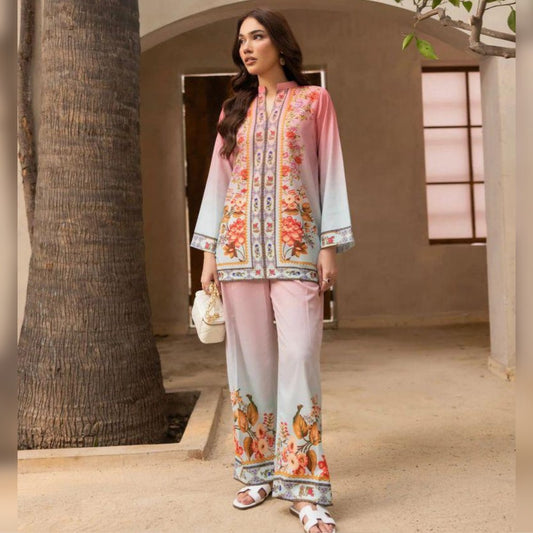 Woman in a floral outfit standing in a sunlit outdoor setting.