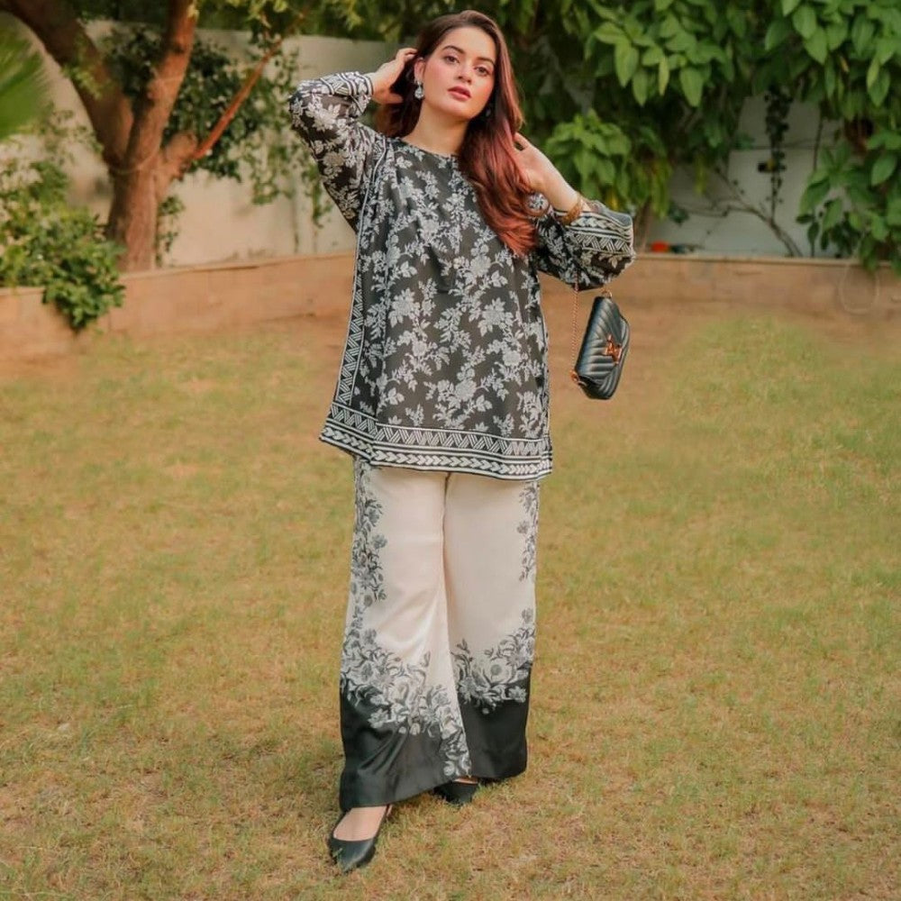 Woman in a floral outfit standing outdoors with greenery in the background