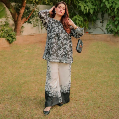 Woman in a floral outfit standing outdoors with greenery in the background