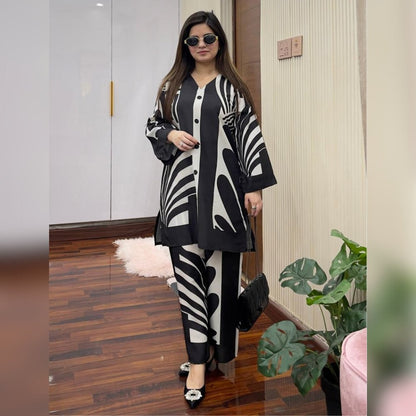 Woman wearing a black and white patterned outfit in an indoor setting.