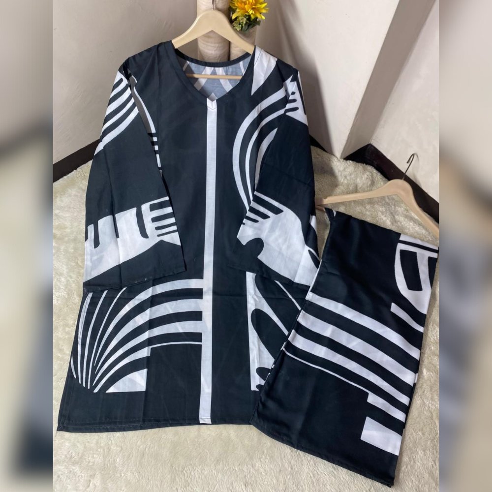 Black and white patterned jacket and shorts set on a beige surface with a neutral background.