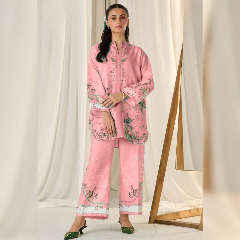 Woman wearing a pink floral outfit standing against a white curtain backdrop
