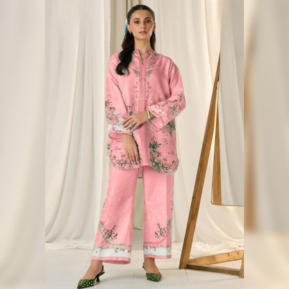 Woman wearing a pink floral outfit standing against a white curtain backdrop