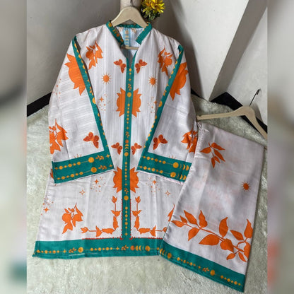 White outfit with orange and green floral patterns on hangers against a neutral background