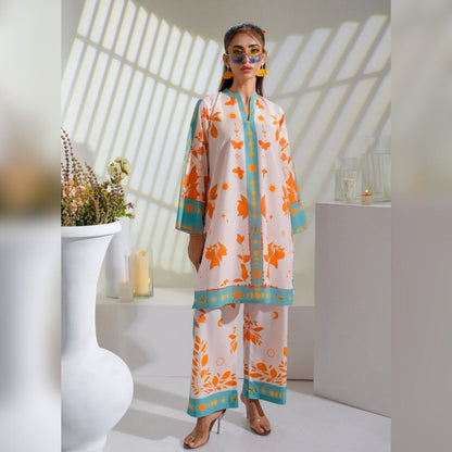 Woman wearing a floral outfit in a bright room with sunlight filtering through.