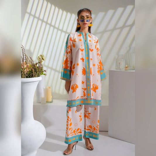 Woman wearing a floral outfit in a bright room with sunlight filtering through.