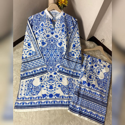 Blue and white patterned shirt and skirt set on hangers against a neutral wall.