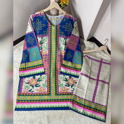 Colorful embroidered traditional outfit with a jacket and saree on hangers against a white background.