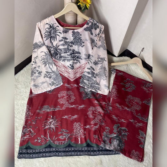 Two patterned dresses on hangers against a white wall.